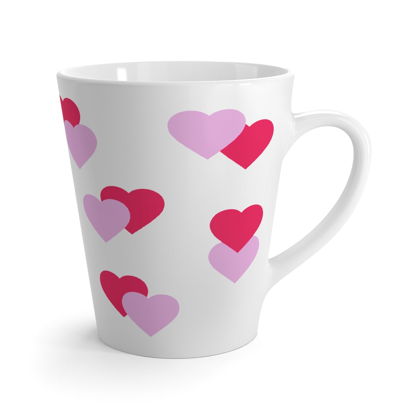White mug with pink and purple heart patterns on a white background