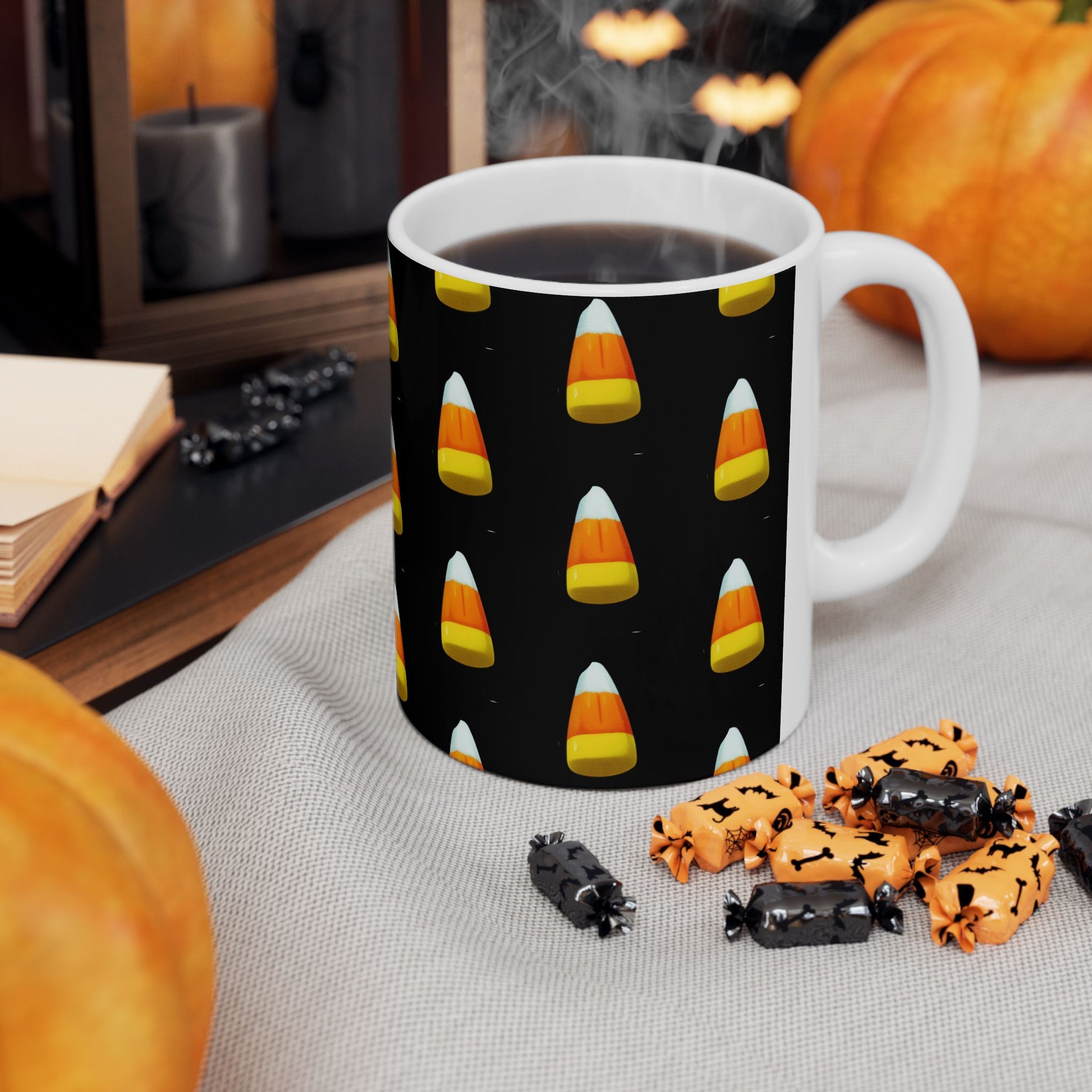 Candy Corn Delight Mug is a white ceramic mug with a black background, decorated with orange candy corns pattern. The mug is placed on a cloth surface with scattered Halloween candy around it.